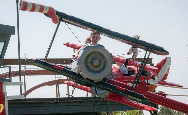 Children on aeroplane theme park ride
