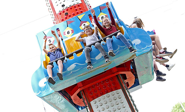 Children on drop tower amusement park ride