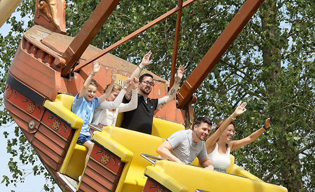 Families on pirate ship theme park ride