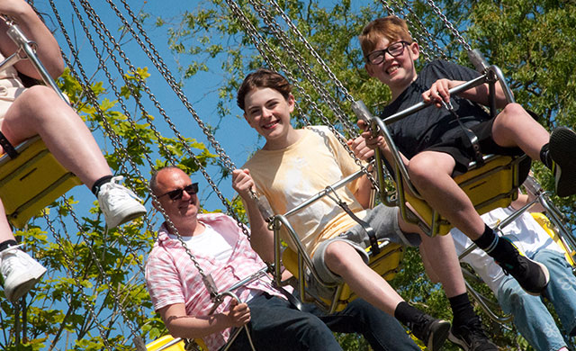 Family on swings at a theme park